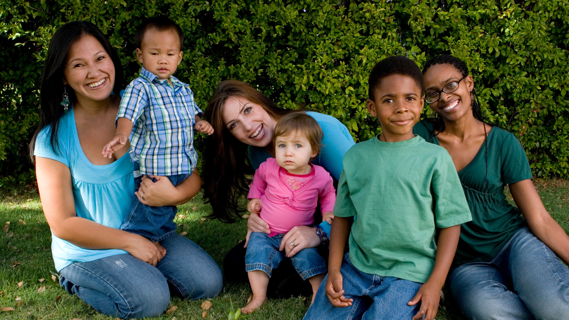 three moms with children outside posing for a picture