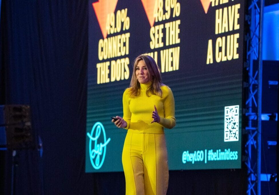 Sales Keynote Speaker Laura Gassner Otting on Stage wearing bright yellow