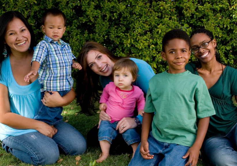 three moms with children outside posing for a picture